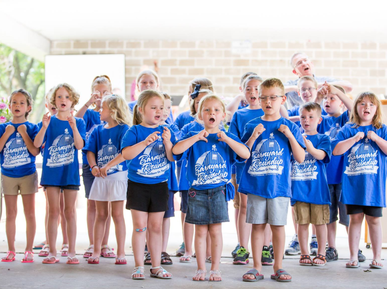 Children girl's left hand wrap around toddler while reading book during golden hour